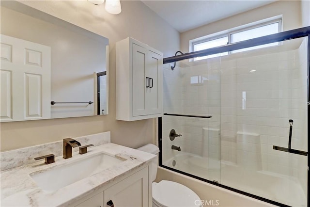 full bathroom with toilet, shower / bath combination with glass door, and vanity