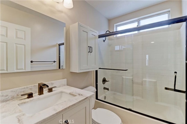 bathroom with shower / bath combination with glass door, toilet, and vanity
