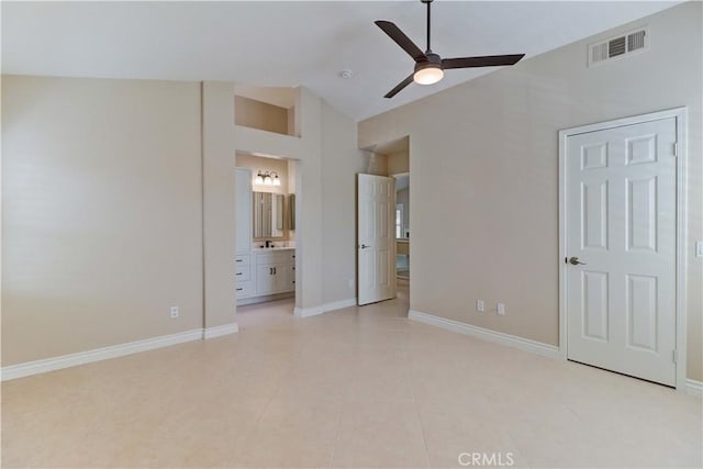 unfurnished bedroom with light tile patterned floors, baseboards, visible vents, ensuite bathroom, and vaulted ceiling