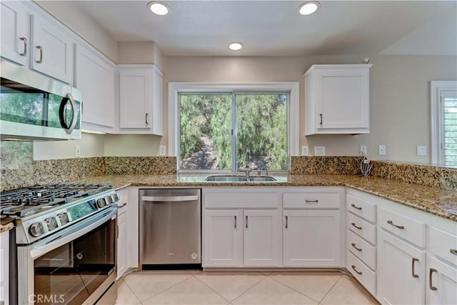 kitchen with white cabinets, stainless steel appliances, a healthy amount of sunlight, and a sink