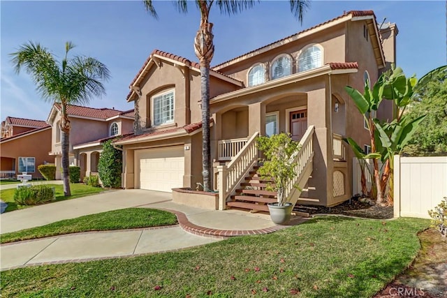 mediterranean / spanish house featuring driveway, fence, an attached garage, and stucco siding