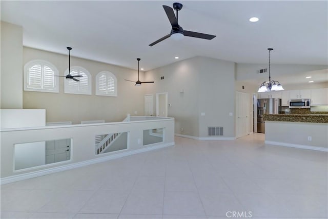 interior space featuring recessed lighting, visible vents, vaulted ceiling, and ceiling fan with notable chandelier