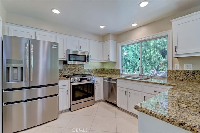 kitchen with white cabinetry, appliances with stainless steel finishes, a sink, and light tile patterned floors