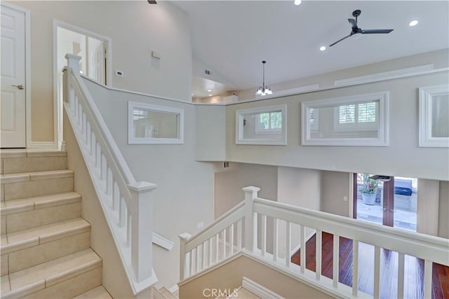 stairway featuring vaulted ceiling, a ceiling fan, and recessed lighting