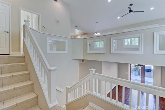 staircase with recessed lighting, ceiling fan, vaulted ceiling, and a wealth of natural light