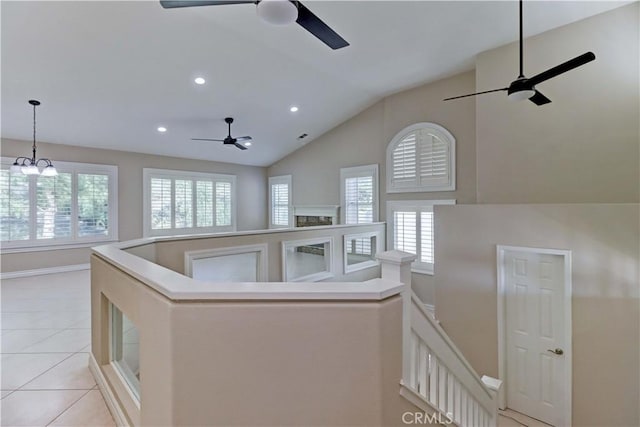 corridor with lofted ceiling, light tile patterned floors, recessed lighting, and an upstairs landing