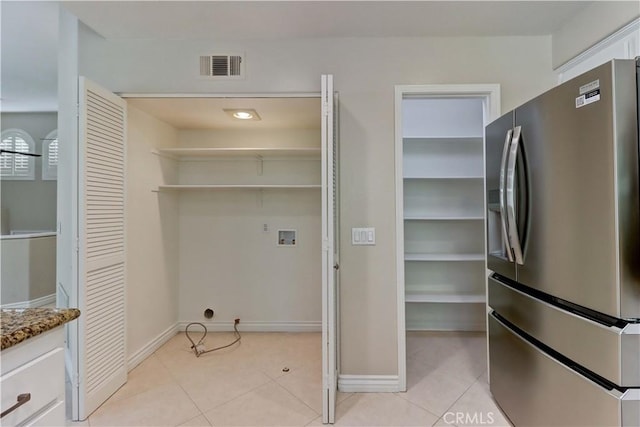 clothes washing area with hookup for a washing machine, visible vents, light tile patterned floors, and laundry area