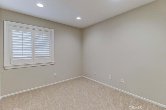 spare room with recessed lighting, light colored carpet, and baseboards