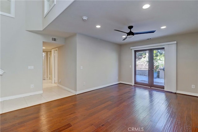 unfurnished room featuring wood-type flooring, a ceiling fan, visible vents, and french doors