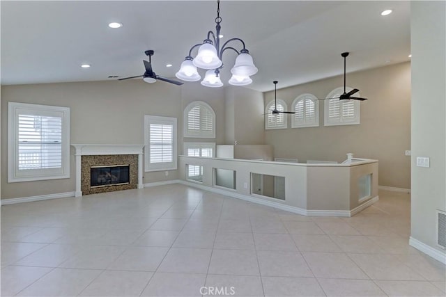 unfurnished living room with baseboards, a high end fireplace, ceiling fan with notable chandelier, and tile patterned flooring