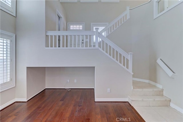 staircase with baseboards and wood finished floors