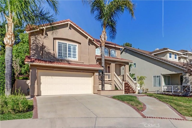 mediterranean / spanish-style house with covered porch, an attached garage, driveway, and stucco siding