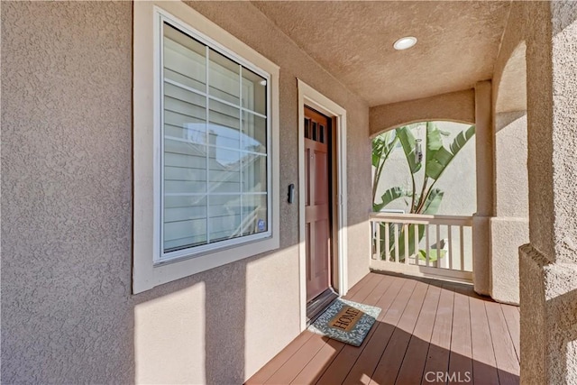 doorway to property featuring stucco siding and a balcony