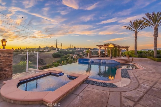 pool at dusk featuring an in ground hot tub, a patio, and a pergola