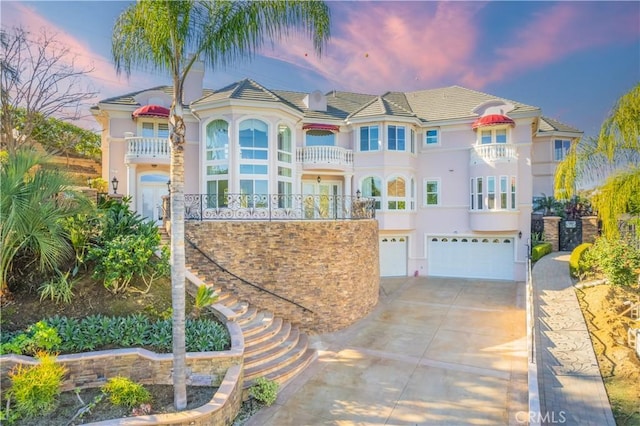 view of front of home with a garage and a balcony