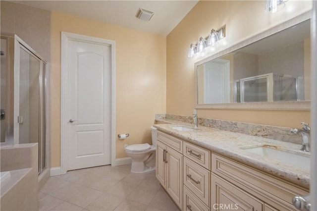 bathroom featuring tile patterned flooring, vanity, toilet, and a shower with shower door