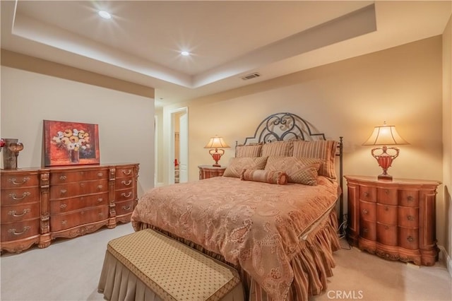 bedroom with a tray ceiling and carpet floors