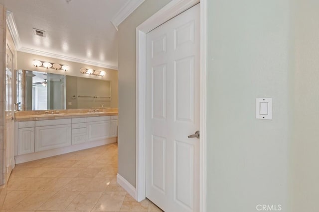 bathroom featuring visible vents, crown molding, a sink, and double vanity