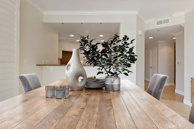 dining space featuring visible vents, crown molding, baseboards, and light tile patterned flooring