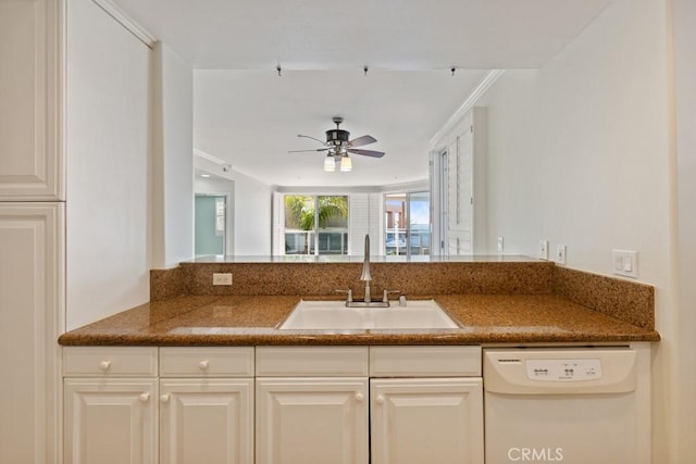 kitchen with ceiling fan, white dishwasher, a sink, and white cabinetry