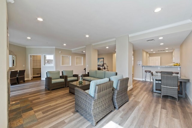 living area featuring light wood-type flooring, baseboards, crown molding, and recessed lighting