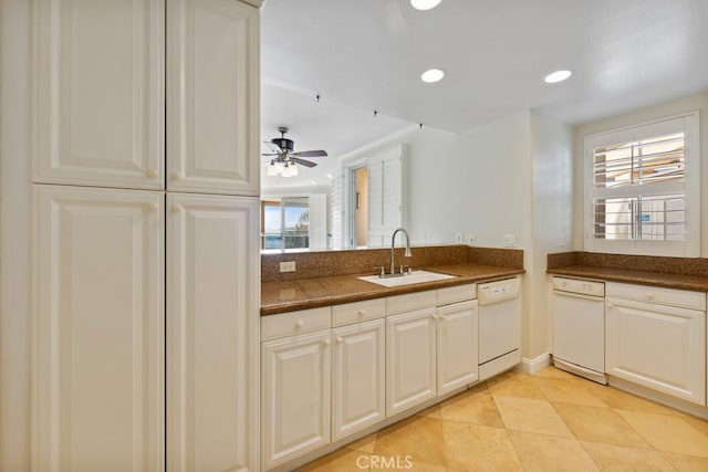 kitchen with a sink, dark countertops, plenty of natural light, and dishwasher