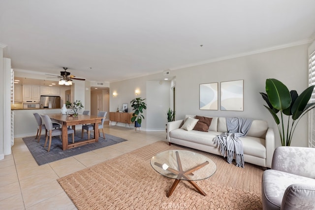 living room featuring ceiling fan, crown molding, baseboards, and light tile patterned floors