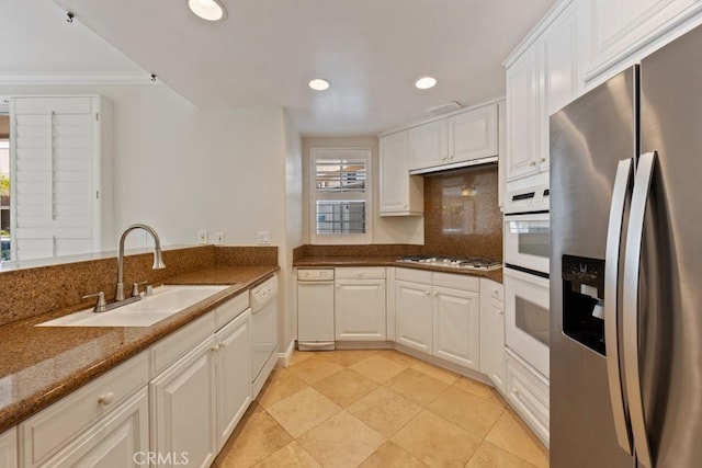 kitchen with white appliances, recessed lighting, a sink, and white cabinets