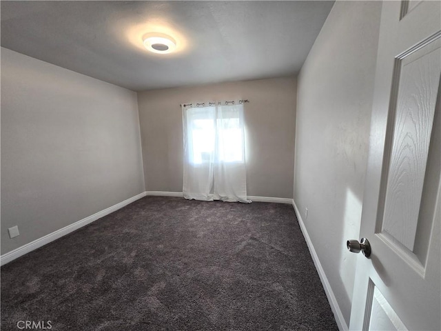 spare room featuring dark carpet