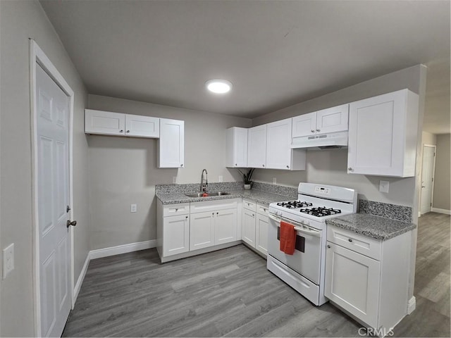 kitchen with light hardwood / wood-style floors, sink, light stone counters, white gas stove, and white cabinets