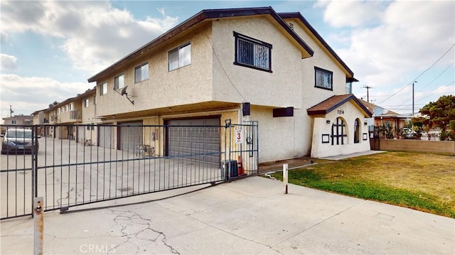 view of front of house featuring a garage, a fenced front yard, concrete driveway, and stucco siding