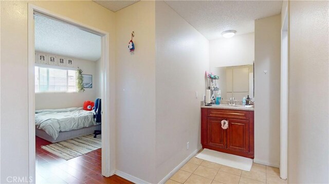 11214 Fineview Unit 5, El Monte, CA 91733 - bathroom with a textured ceiling, connected bathroom, vanity, and baseboards