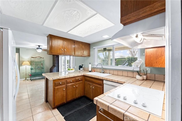 kitchen with a peninsula, tile countertops, and brown cabinetry