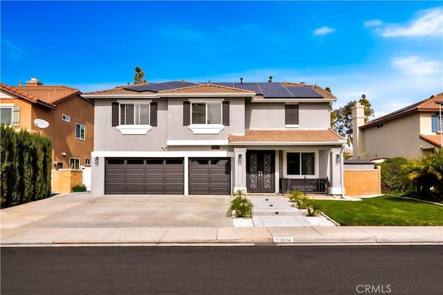 view of front of house with a garage, solar panels, covered porch, and a front yard