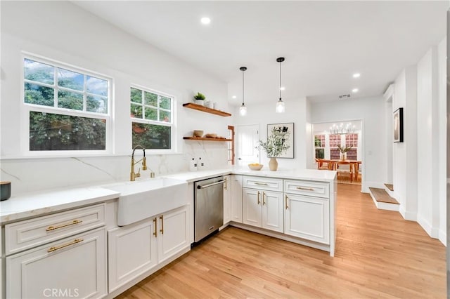 kitchen with a sink, white cabinets, hanging light fixtures, dishwasher, and open shelves