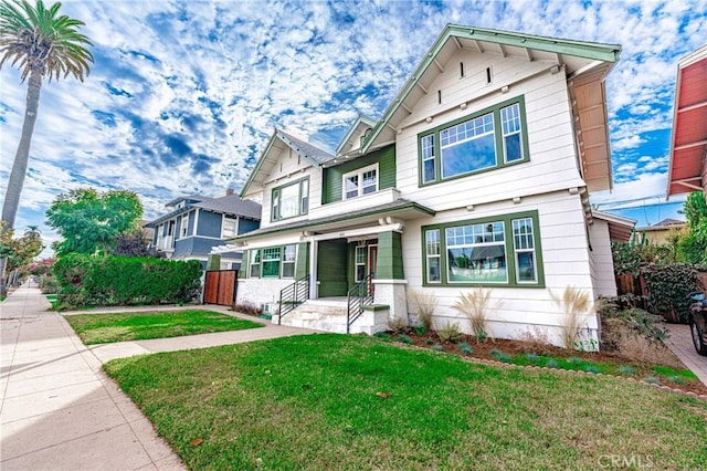 view of front of home with fence and a front lawn