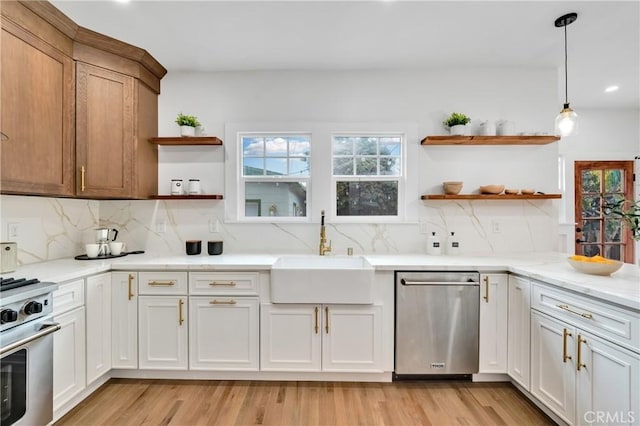 kitchen with appliances with stainless steel finishes, white cabinetry, a sink, and open shelves