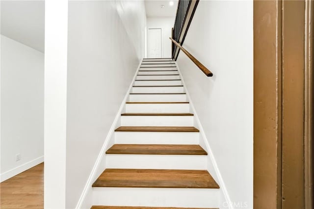 staircase with wood finished floors and baseboards