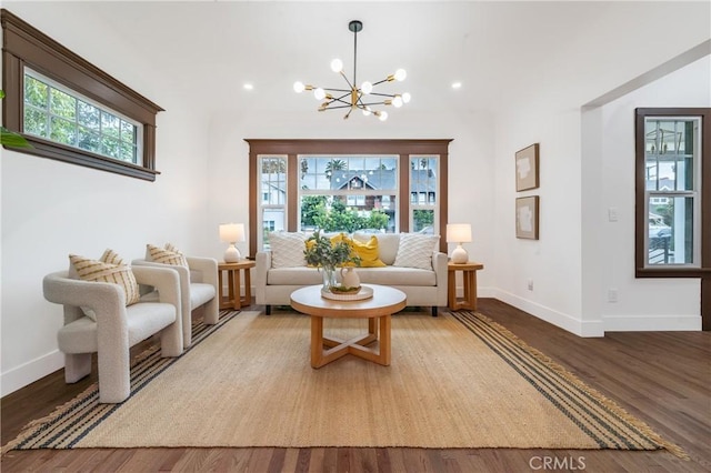 living area with recessed lighting, a notable chandelier, baseboards, and wood finished floors