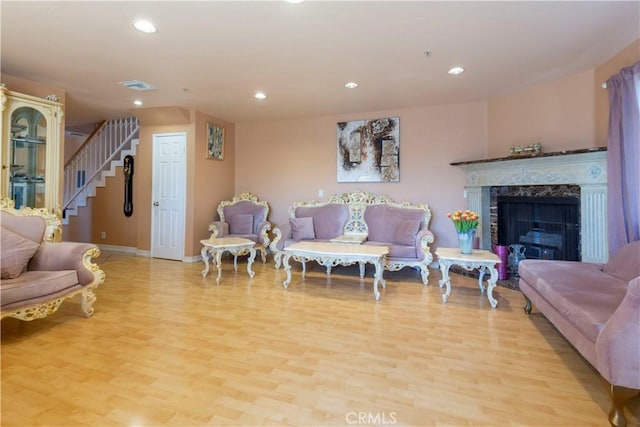 living room featuring a high end fireplace and light hardwood / wood-style floors