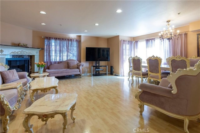 living room with light wood-type flooring, a notable chandelier, and a fireplace