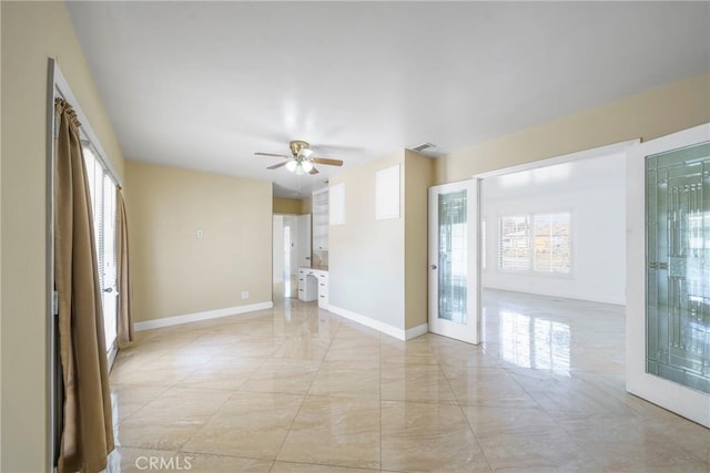 spare room with a ceiling fan, french doors, visible vents, and baseboards