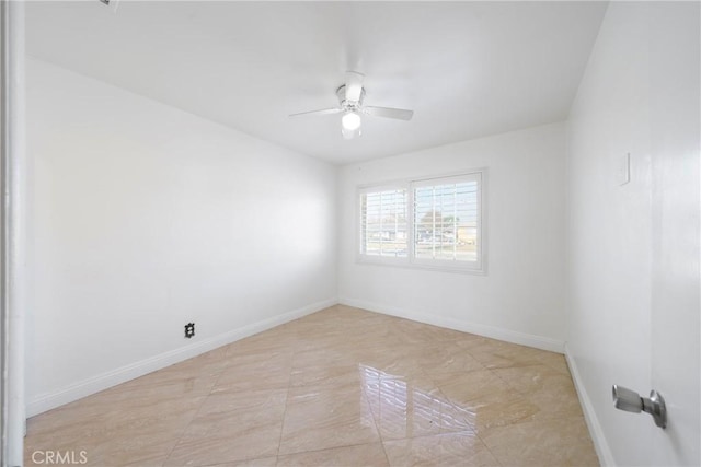 empty room with ceiling fan and baseboards