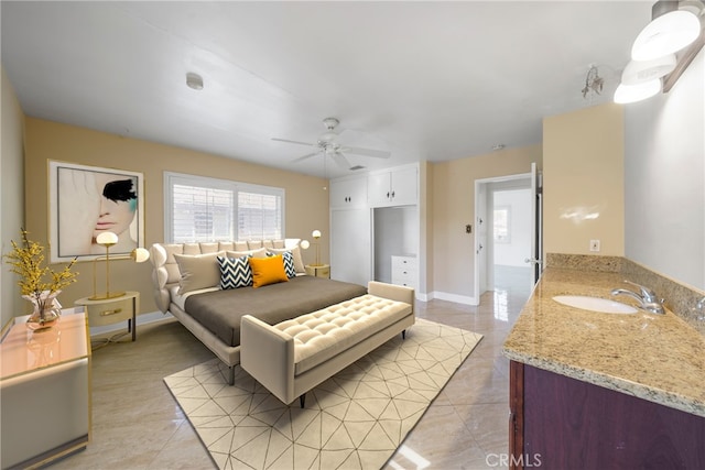 bedroom featuring light tile patterned flooring, a sink, baseboards, and ceiling fan