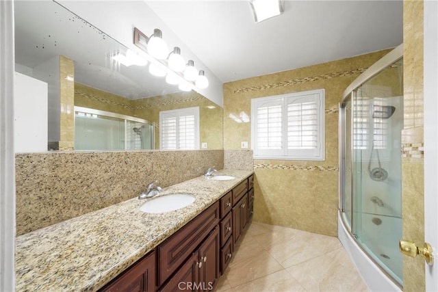 bathroom with double vanity, a sink, tile walls, and tile patterned floors