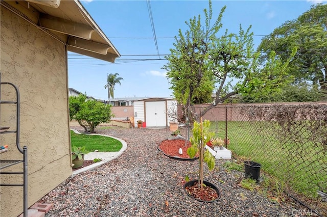 view of yard with a shed, fence, and an outbuilding