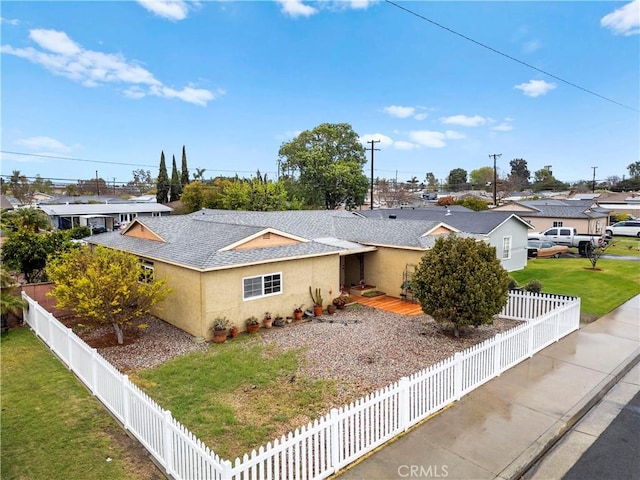 single story home with a shingled roof, a fenced backyard, a front lawn, and stucco siding