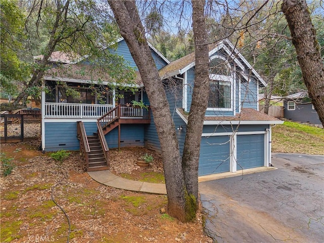 view of front of property featuring an attached garage, a sunroom, stairs, driveway, and crawl space