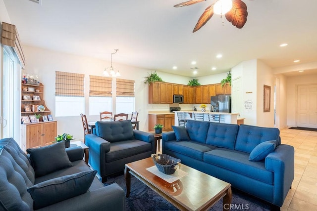 living room with ceiling fan with notable chandelier and light tile patterned floors