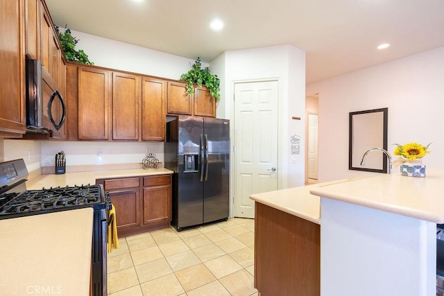 kitchen with a breakfast bar area, stainless steel refrigerator with ice dispenser, gas range, light tile patterned floors, and kitchen peninsula